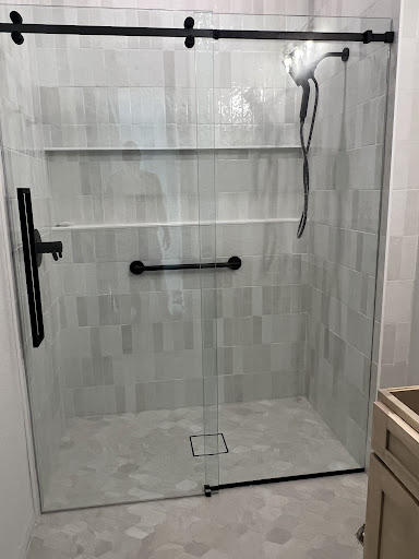 Modern tile replacement, new shower glass and fixtures, and a brand new sink.